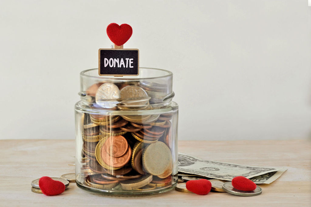 Money jar full of coins with Donate label and hearts