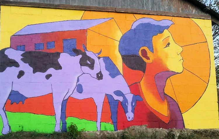 painted mural of two purple cows and a boy